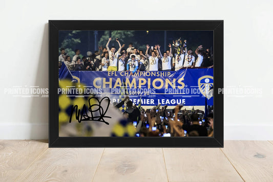 Signed (printed photo) of the 2020 Leeds United Championship squad with the league  trophy. A printed autograph taken from a genuine, certified (certificate of authenticity) autograph. A stunning signature. The print is available in a range of sizes with various framing options available.  Marcelo Bielsa is famous for sitting on his iconic blue bucket.
