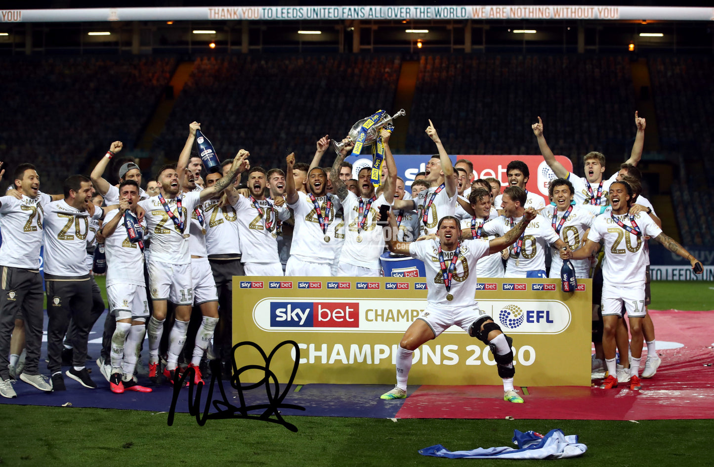 Signed (printed photo) of the 2020 Leeds United Championship squad with the league  trophy. A printed autograph taken from a genuine, certified (certificate of authenticity) autograph. A stunning signature. The print is available in a range of sizes with various framing options available.  Marcelo Bielsa is famous for sitting on his iconic blue bucket.