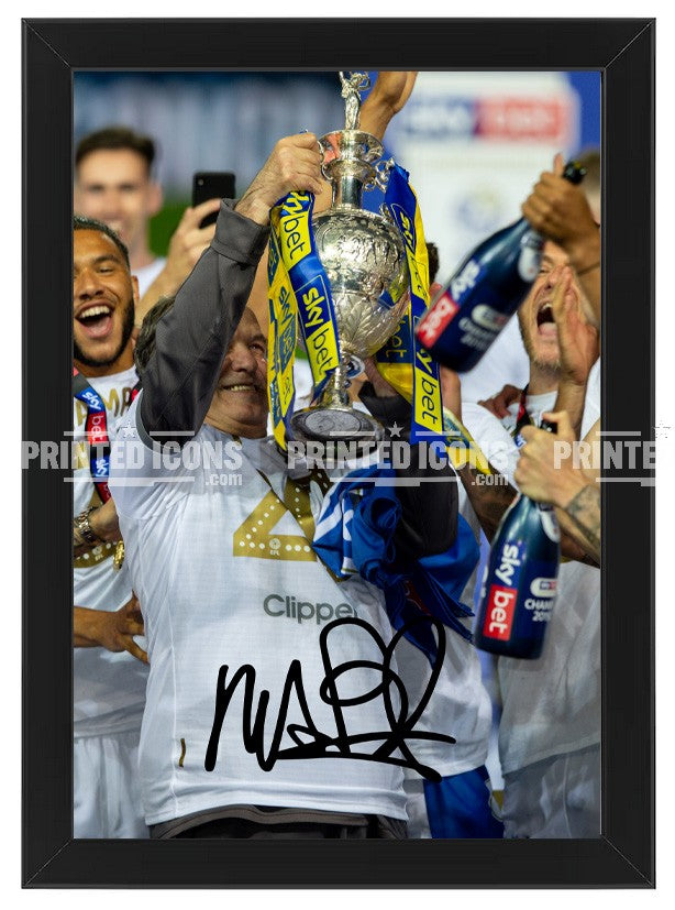 Signed (printed photo) of Marcelo Bielsa managing Leeds United. He is lifting the 2020 Championship trophy. A printed autograph taken from a genuine, certified (certificate of authenticity) autograph. A stunning signature. The print is available in a range of sizes with various framing options available.  Marcelo Bielsa is famous for sitting on his iconic blue bucket. 