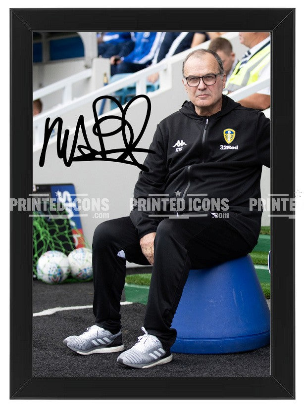 Signed (printed photo) of Marcelo Bielsa managing Leeds United. He is sitting on his iconic blue bucket. A printed autograph taken from a genuine, certified (certificate of authenticity) autograph. A stunning signature. The print is available in a range of sizes with various framing options available.  Marcelo Bielsa is famous for sitting on his iconic blue bucket. 