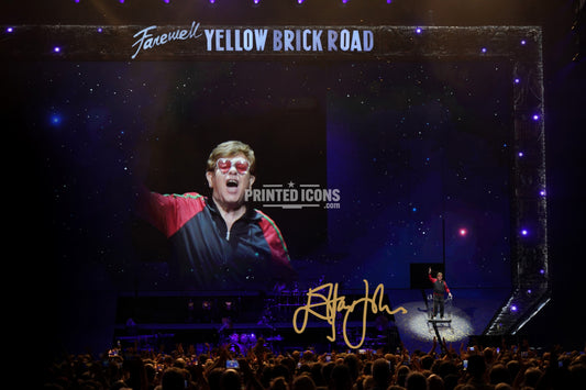 Signed (printed photo) of Elton John. A printed autograph taken from a genuine, certified (certificate of authenticity) autograph. A stunning signature. The print is available in a range of sizes with various framing options available. Yellow Brick Road final tour.