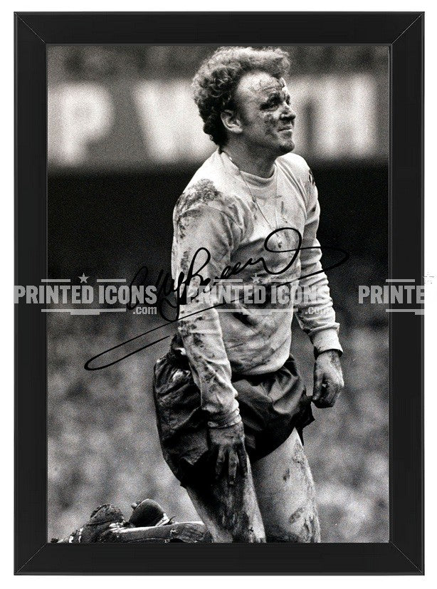 Billy Bremner in the mud signed photo. A printed autograph (from a certified original) on a Leeds United photo. Framing Available. A great gift for a Leeds United fan.