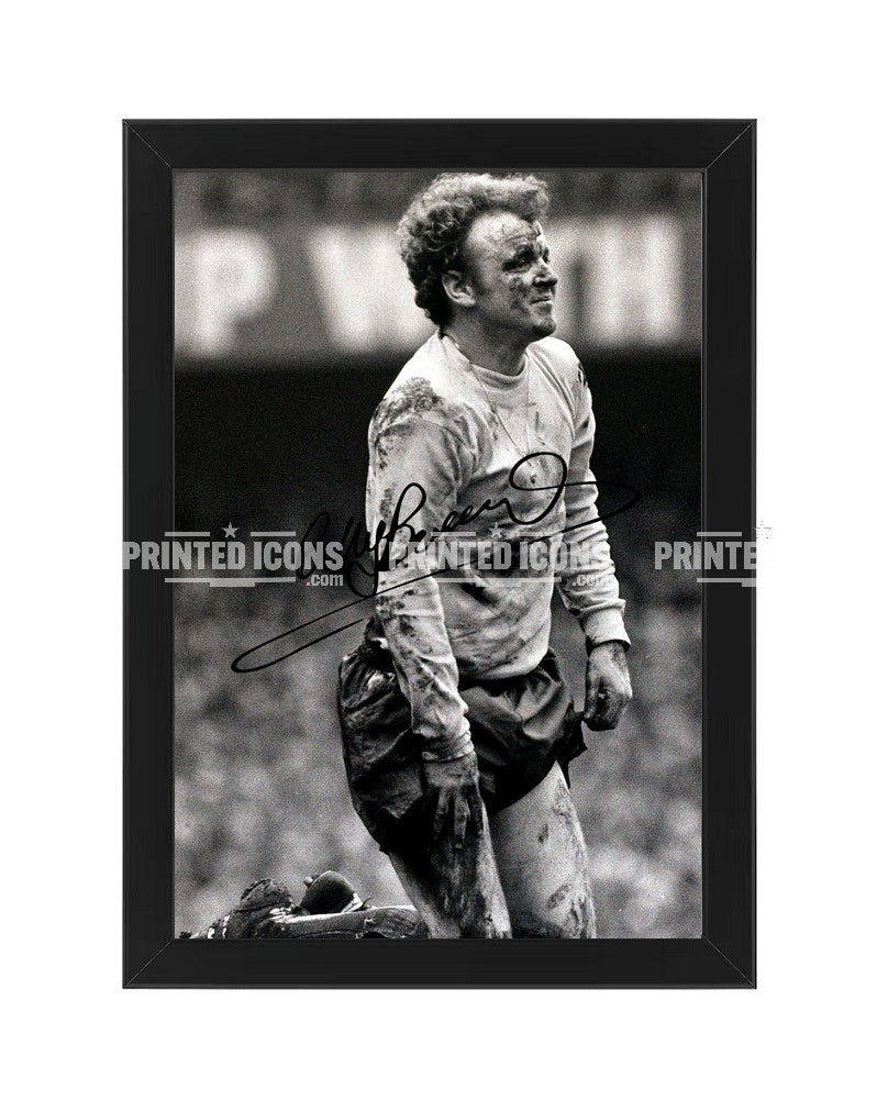 Billy Bremner in the mud signed photo. A printed autograph (from a certified original) on a Leeds United photo. Framing Available. A great gift for a Leeds United fan.